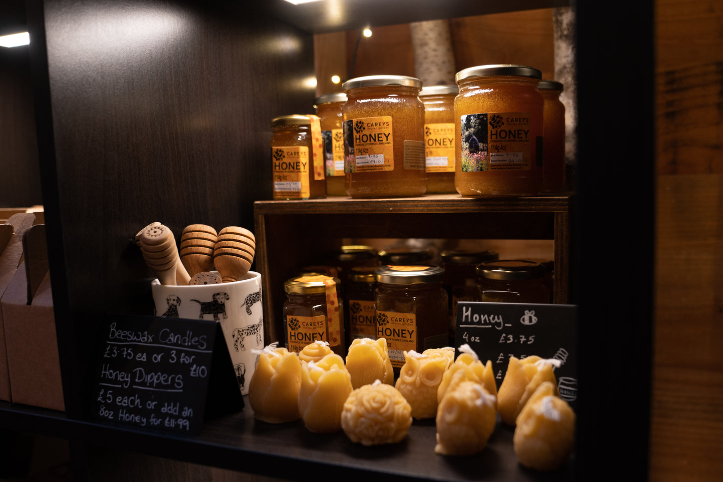 Honey range at Carey’s, showcasing various sizes of jars, beeswax candles, and gift sets, all sourced from the garden’s hives, offering natural local products