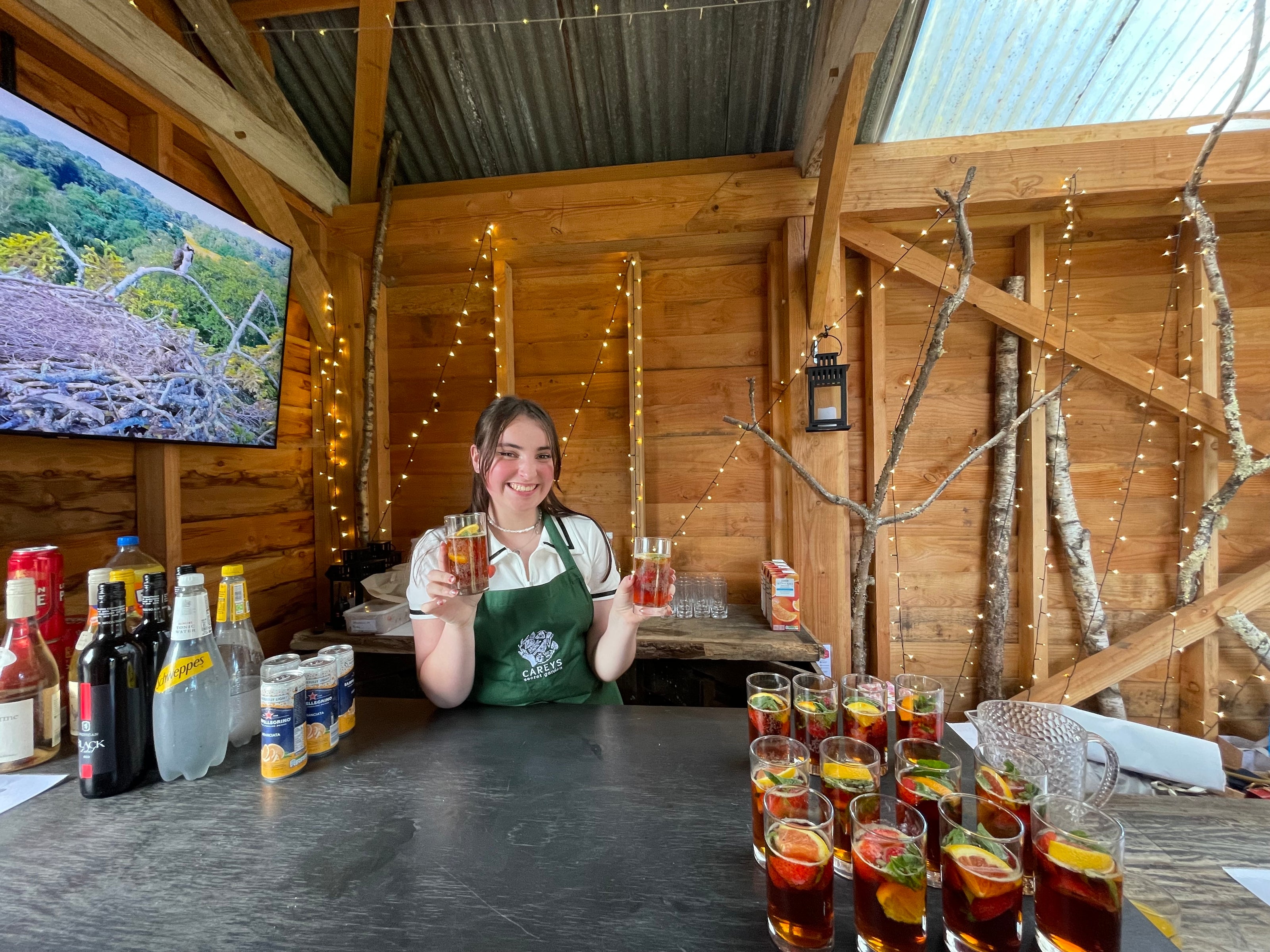 Young woman serving refreshments in the Reclaimed Barn at Carey’s, offering drinks in a rustic, charming setting perfect for gatherings and events