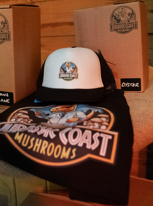 Jurassic Coast Mushrooms trucker caps and t-shirts, featuring the brand’s logo and design, offering stylish, eco-friendly apparel for mushroom enthusiasts and nature lovers.