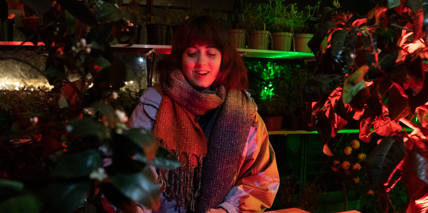 Image of young woman cosy in the illuminated Greenhouse at Careys in the Winter 