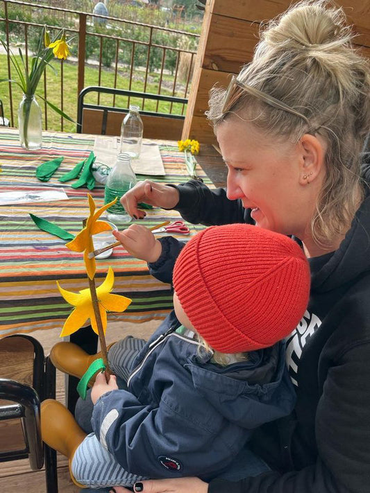 Toddler and mum crafting daffodils together at Carey’s during a weekly parent and toddler group, enjoying a creative, nature-inspired activity in a welcoming outdoor setting