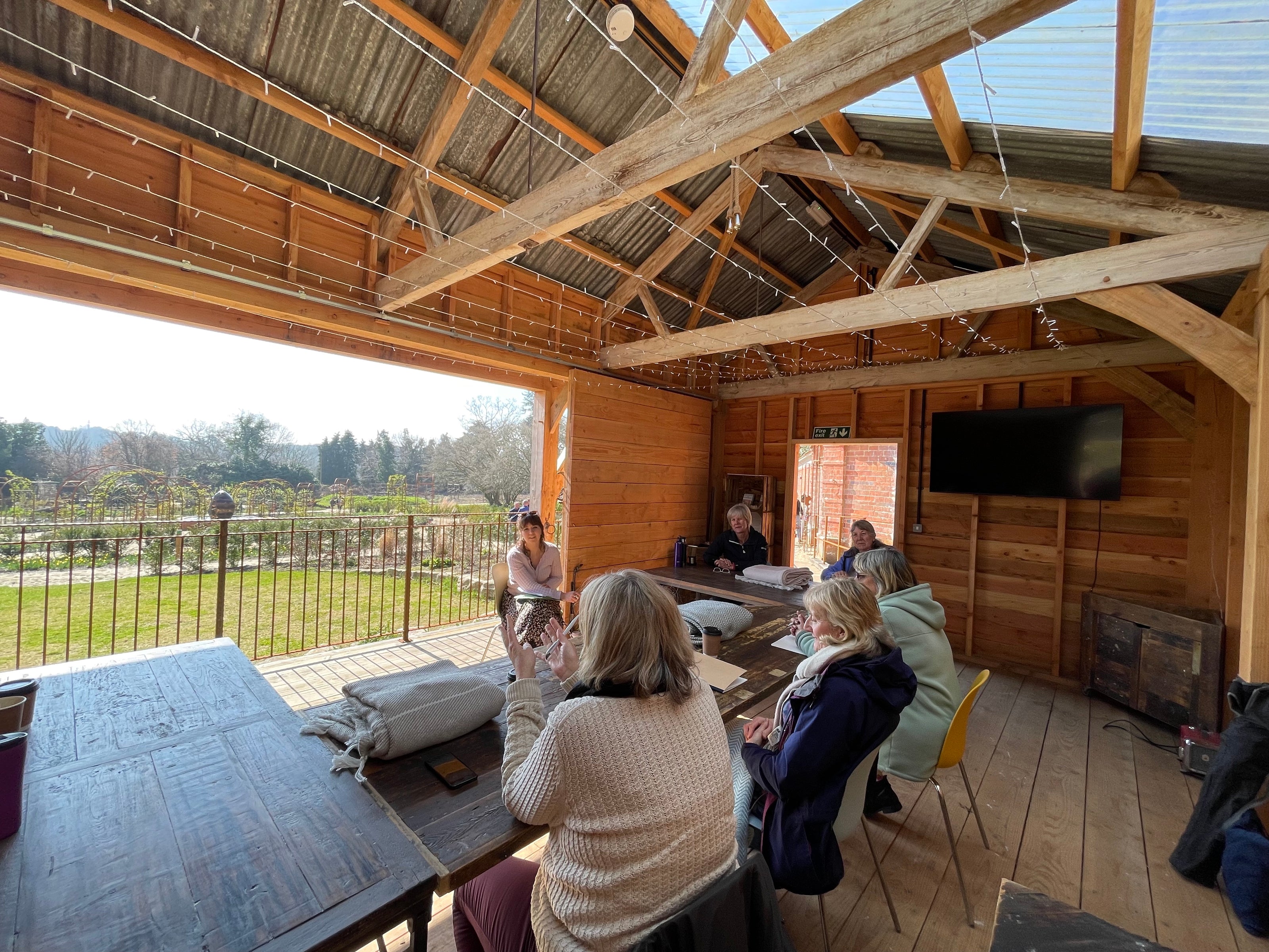 Writing workshop in progress inside the Reclaimed Barn at Carey’s, with participants gathered in a cozy, rustic setting, surrounded by creativity and nature.